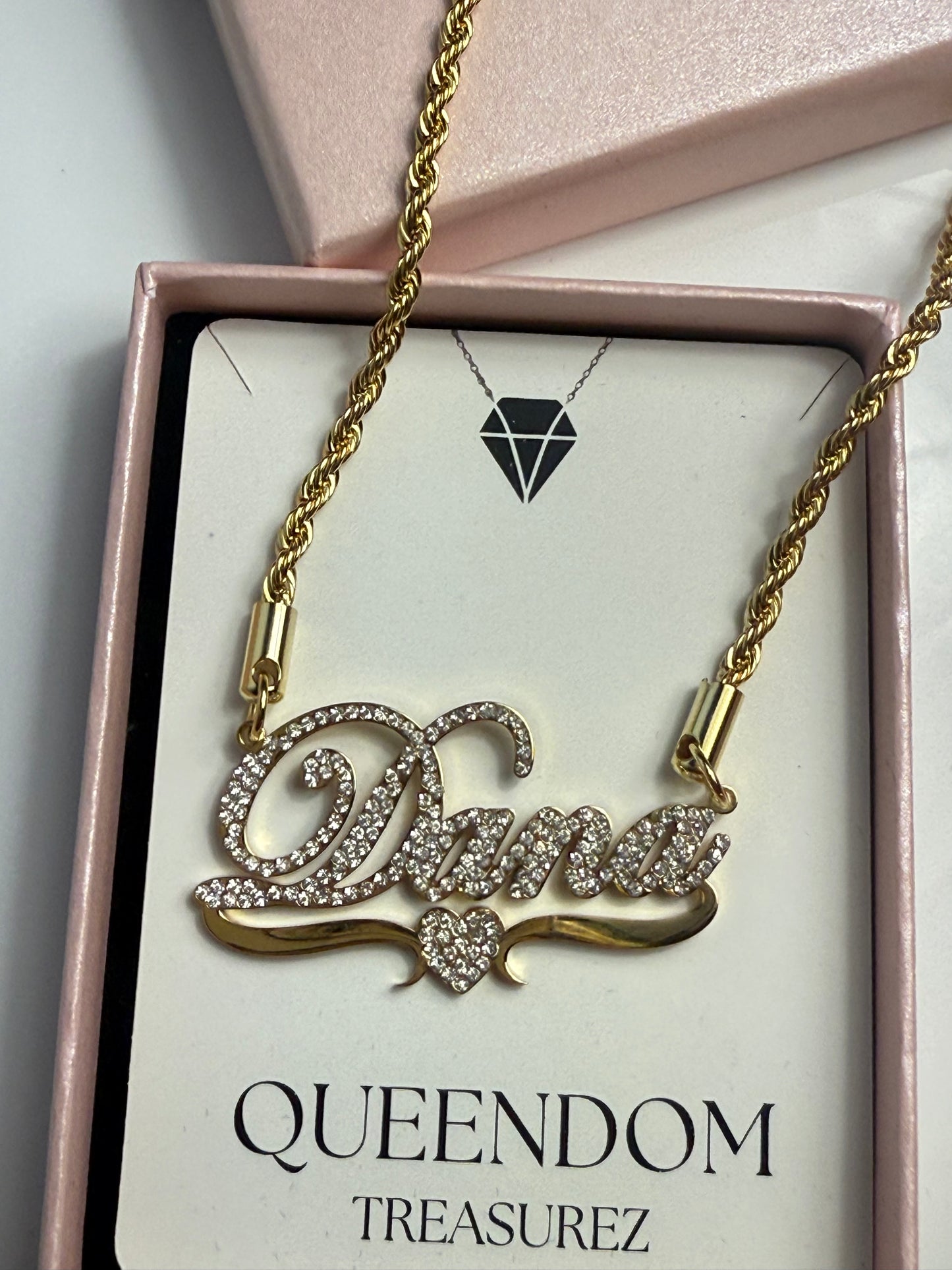 Cat-shaped necklace with gold chain on a QUEENDOM TREASUREZ branded card.