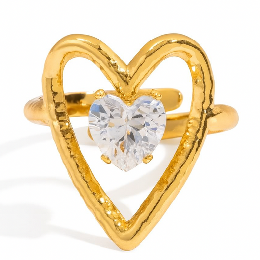 Gold heart-shaped ring with a clear gemstone on a white background