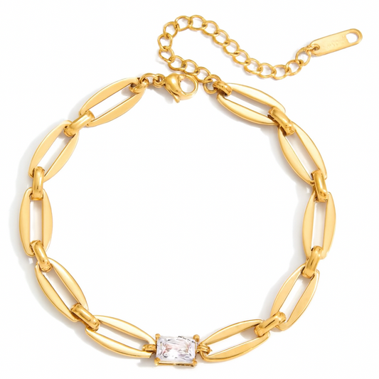 Gold chain bracelet with a central diamond on a white background