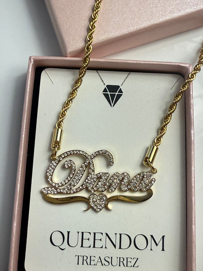 Cat-shaped necklace with gold chain on a QUEENDOM TREASUREZ branded card.
