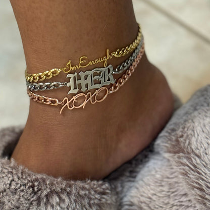 Ankle with multiple gold silver and rose gold bracelets on a neutral background