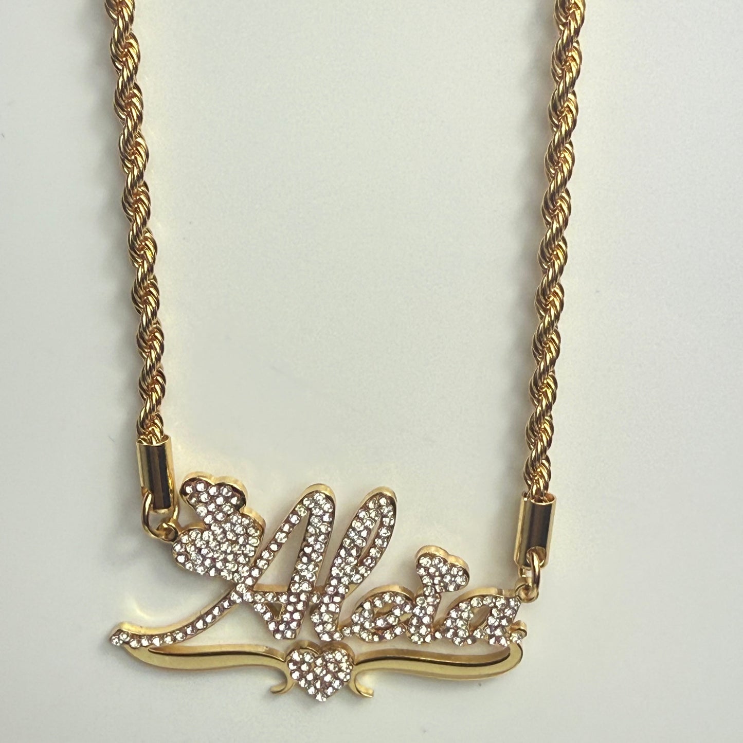Gold necklace with a decorative clasp on a light gray background