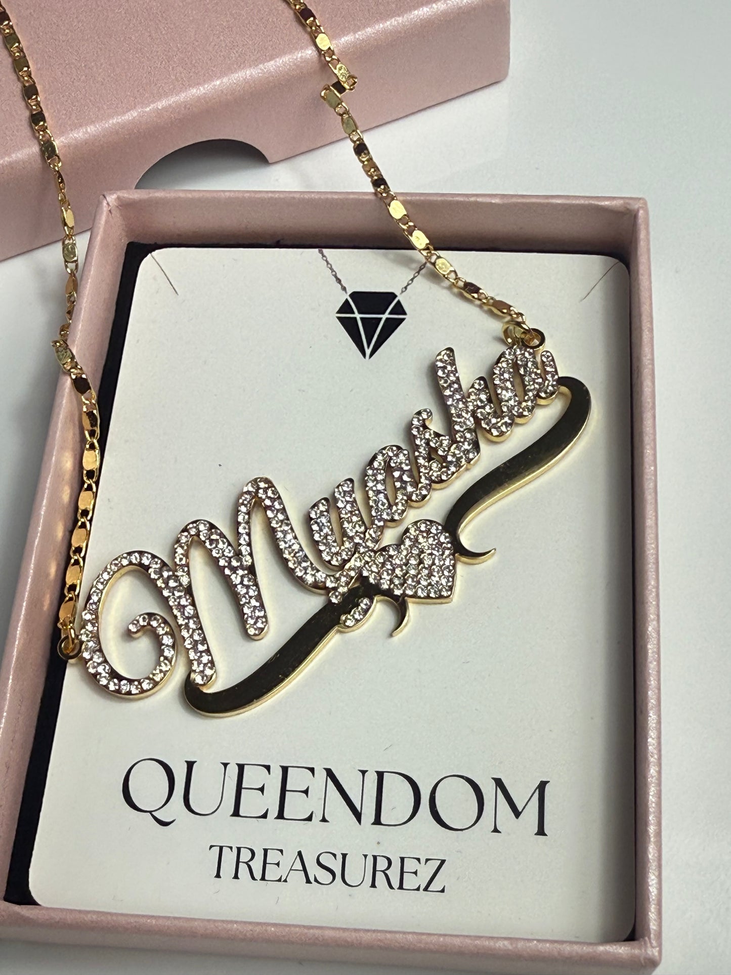 Necklace with 'QUEENDOM' pendant on a 'QUEENDOM TREASUREZ' card