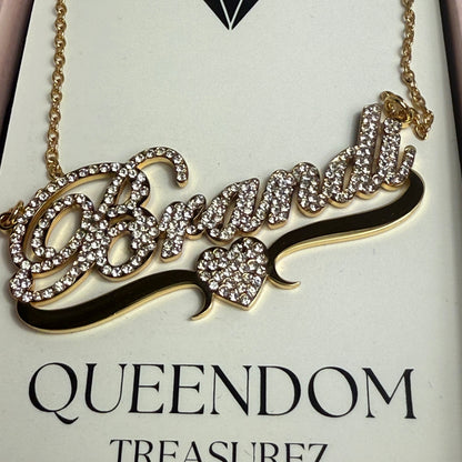 Decorative necklace with intricate design on a 'QUEENDOM TREASUREZ' branded card.