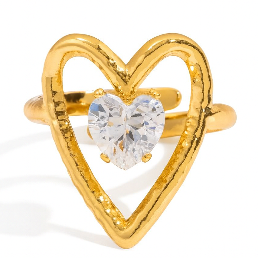 Gold heart-shaped ring with a clear gemstone on a white background