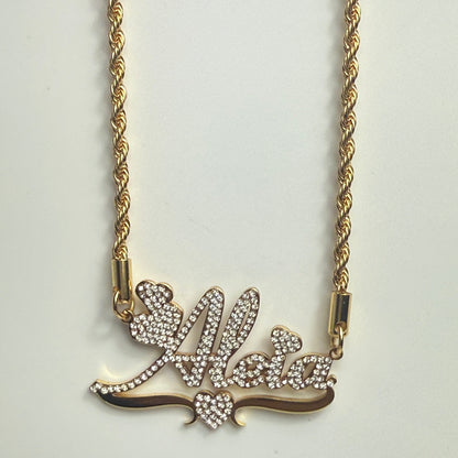 Gold necklace with a decorative bow pendant on a light gray background