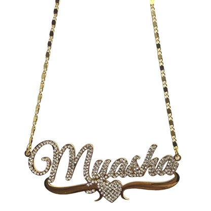 Gold necklace with a leaf-shaped pendant on a light gray background