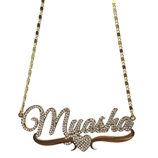 Gold necklace with a leaf-shaped pendant on a light gray background